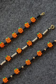 the beads are made to look like oranges and white flowers on black bead