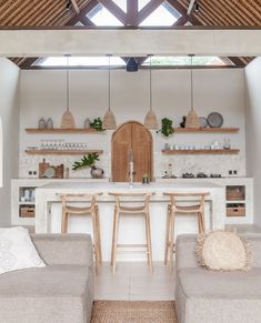 a living room filled with furniture next to a kitchen