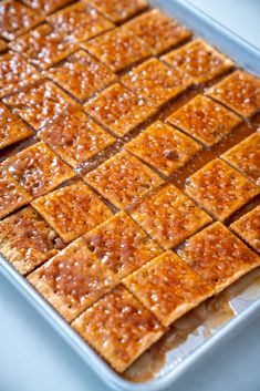 square pieces of food sitting on top of a pan covered in brown sugar and caramel