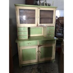 an old green and white cabinet with glass doors