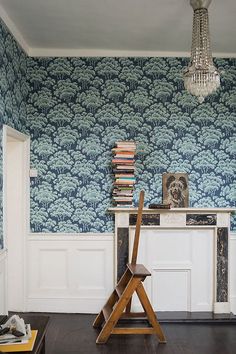 an image of a room with blue wallpaper and wooden furniture in it, including a desk