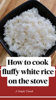 white rice in a black bowl on top of a wooden table next to a red border