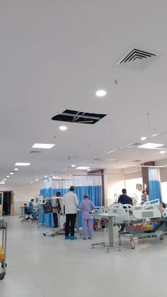 doctors and nurses in an operating room with blue drapes on the ceiling above them