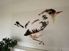 a white wall with a bird made out of legos