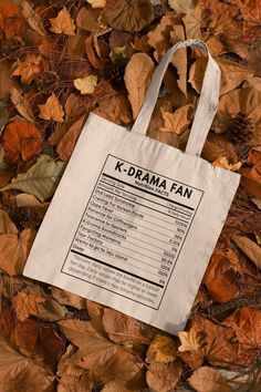 a tote bag with the k - drama fan list on it laying in leaves