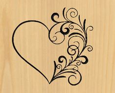 a heart with swirls and leaves carved into it on a wooden background, in the shape of a frame