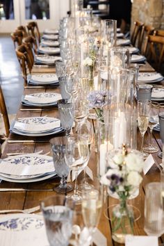 a long table is set with glasses and plates