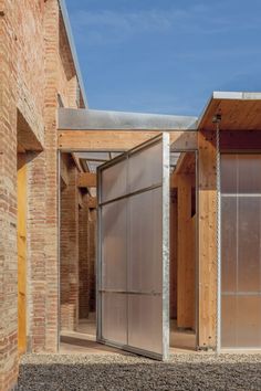 an open garage door on the side of a brick building with wood and glass doors