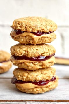 three oatmeal cookies stacked on top of each other with peanut butter and jelly