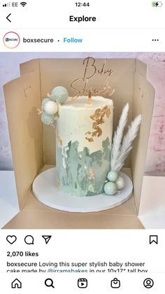 a box with a cake in it that says baby on the top and an image of a feather