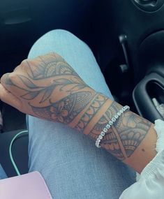 a person with a tattoo on their arm sitting in a car