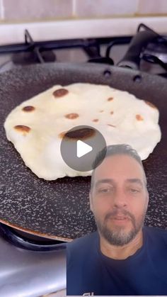 a man standing in front of a frying pan with food on top of it