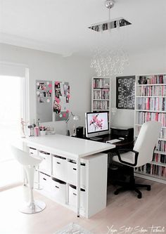 a home office with lots of bookshelves, desk and chairs in front of the window