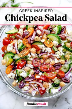 chickpea salad in a glass bowl with the title text overlay reads greek inspired chickpea salad