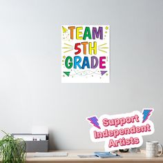 there is a sign that says team 5th grade and support independent artists on the wall