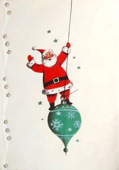 a santa clause is hanging from a string on a christmas ornament with snowflakes