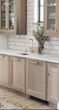 a kitchen with wooden cabinets and marble counter tops, along with a rug on the floor