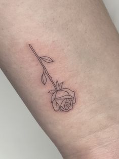 a single rose tattoo on the left side of the leg, it is black and white