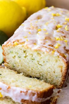 a loaf of lemon zucchini bread sitting on top of a table next to two lemons