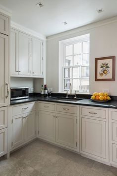 a kitchen with white cabinets and black counter tops is seen on the appliance