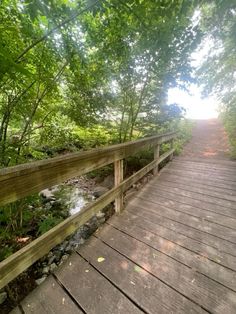 a wooden bridge over a small stream in the woods