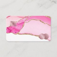 a business card with pink and gold paint