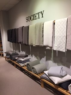 a row of folded towels on display in a room with the word society above it