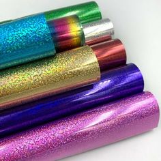 four rolls of holographic paper are stacked on top of each other in different colors