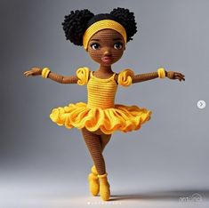 a crocheted doll wearing a yellow dress and headband with her arms outstretched