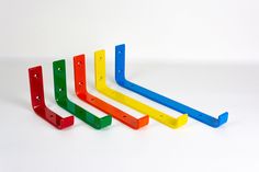 four different colored plastic pegs on a white surface with no one in the photo