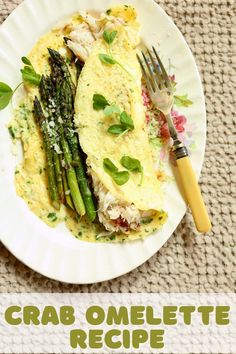 a white plate topped with an omelet and asparagus