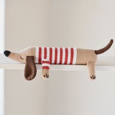 a crocheted dog is laying on the shelf