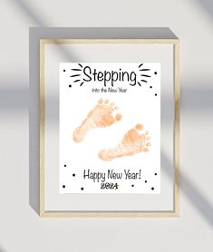 a framed poster with a baby's hand and foot prints on the bottom right corner