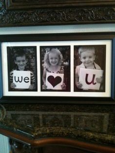 two children holding up pictures with the words we love u on them in front of a fireplace