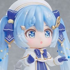 an anime figurine with blue hair and gold accents on her head, holding a white plate