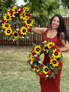 a woman holding a wreath with sunflowers on it