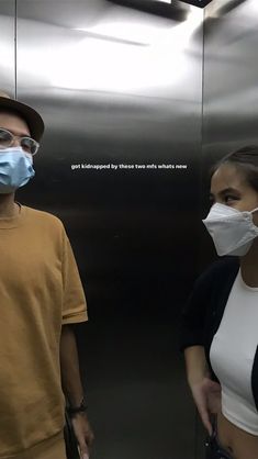 a man and woman wearing face masks in an elevator