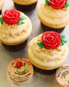 several cupcakes with frosting and red roses on them