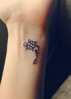 a small tattoo on the wrist of a girl with an elephant and turtle symbol in it