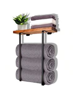 a shelf with towels and a potted plant on it