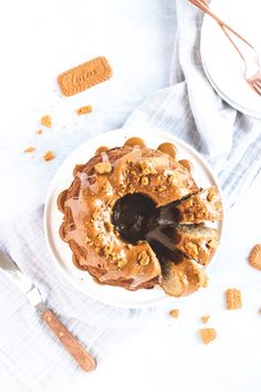 a white plate topped with a bundt cake covered in frosting and toppings