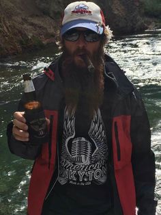 a man with a long beard holding a beer