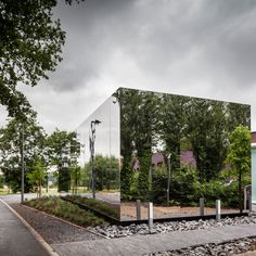 a mirrored building with trees in the background