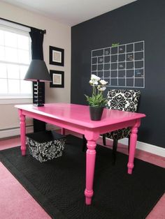 a red table in a room with black and white decor on the wall behind it