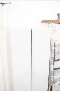 a white refrigerator freezer sitting next to a wooden rack with towels hanging on it