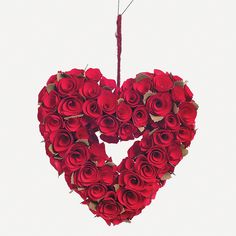 a heart shaped arrangement of red roses hanging from a wire