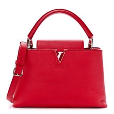 This is an authentic LOUIS VUITTON Taurillon Capucines BB in Rubis. This handbag is crafted of textured taurillon calfskin leather in red. The bag features a looping rolled leather top handle with silver ring links, and an optional, adjustable shoulder strap. The crossover flap opens to a partitioned red leather interior with a zipper pocket. Leather Interior, Authentic Louis Vuitton, Leather Top, Crossover, Red Leather, Top Handle, Zipper Pocket, Calf Skin, Silver Ring