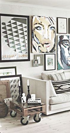 a living room filled with furniture and pictures on the wall