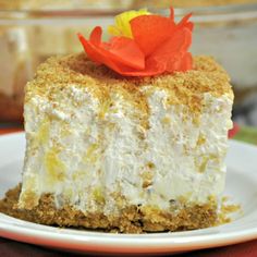 a piece of cheesecake on a plate with a red flower in the top corner