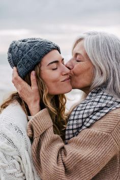 two women kissing each other on the beach